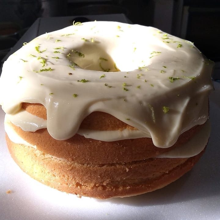 Bolo com cobertura branca e raspas cítricas