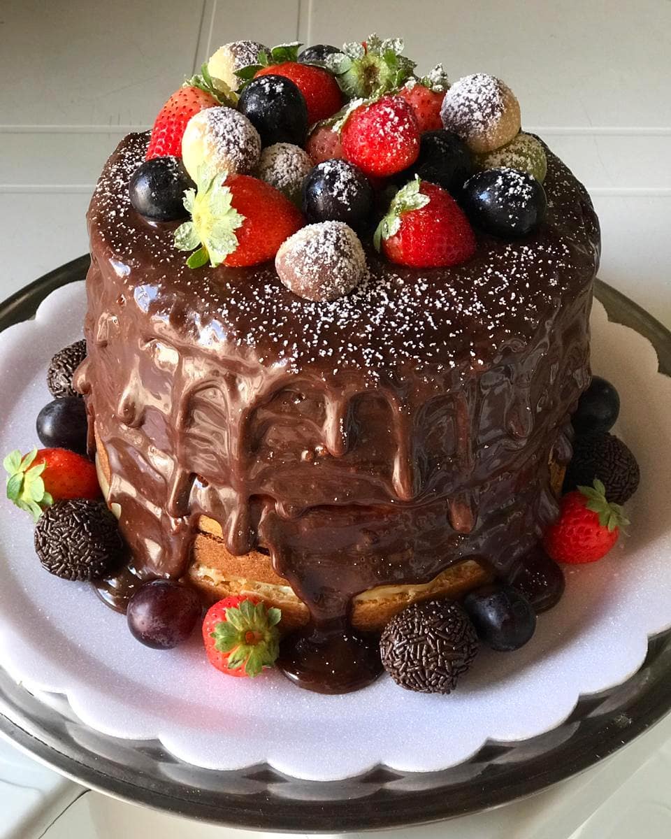 Bolo de chocolate, frutas e brigadeiros