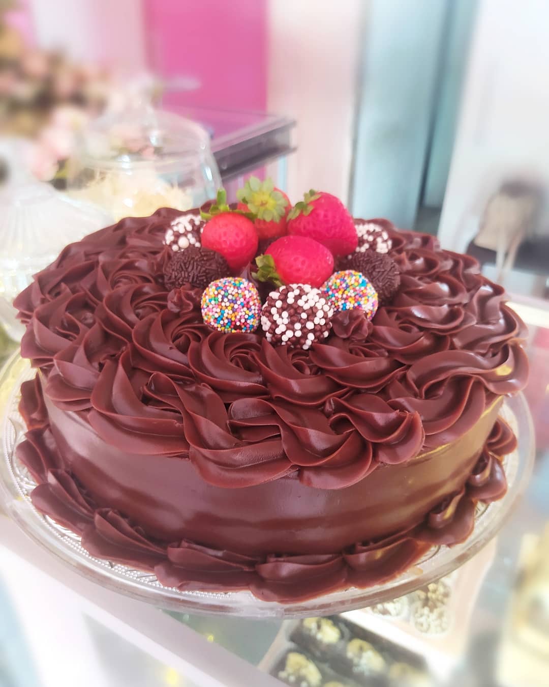 Bolo de chocolate decorado com morangos e docinhos