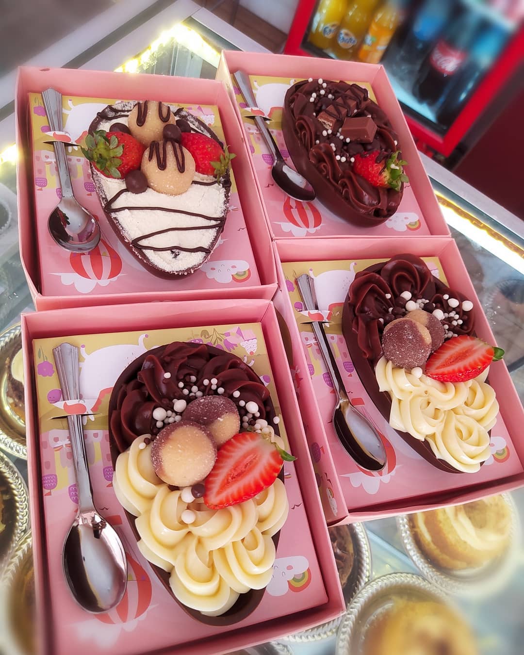 Sobremesas individuais com cremes, chocolate e morangos